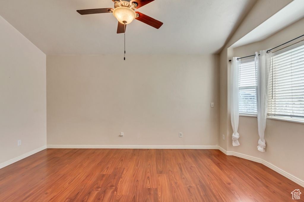 Unfurnished room featuring vaulted ceiling, ceiling fan, and hardwood / wood-style flooring