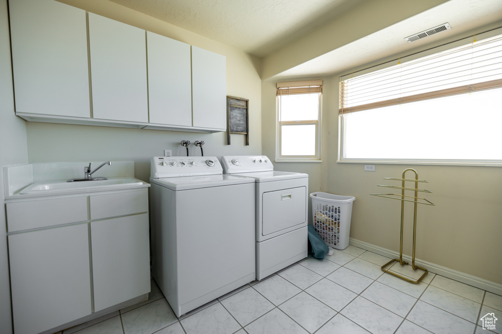 Laundry room with cabinets, sink, light tile floors, washer and clothes dryer, and hookup for a washing machine
