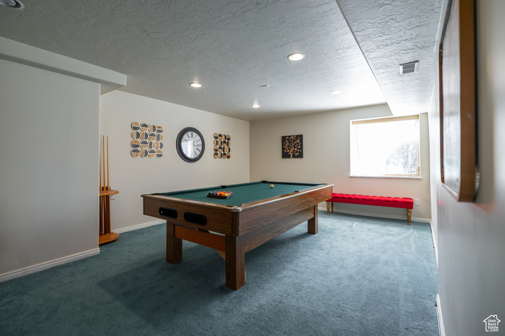 Recreation room featuring a textured ceiling, billiards, and dark carpet