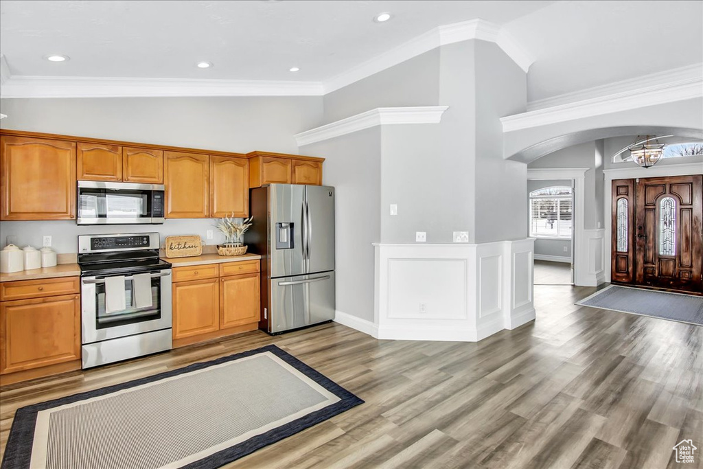 Kitchen with crown molding, stainless steel appliances, a chandelier, and light hardwood / wood-style flooring