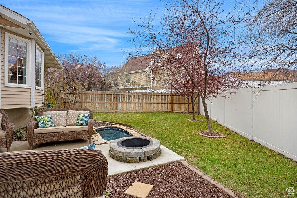 View of yard with an outdoor living space with a fire pit and a patio area