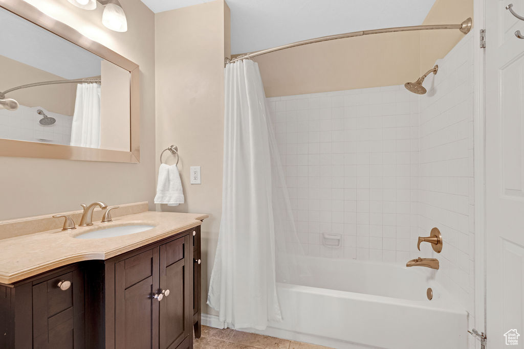 Bathroom with vanity, tile flooring, and shower / tub combo with curtain