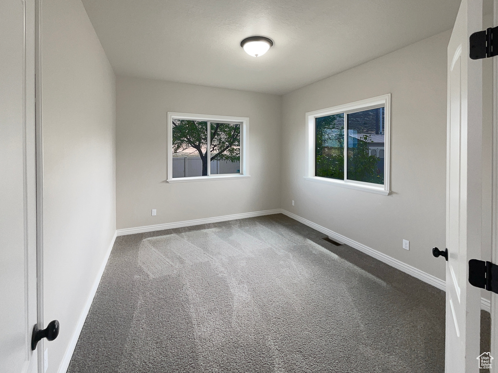 Spare room featuring carpet and baseboards
