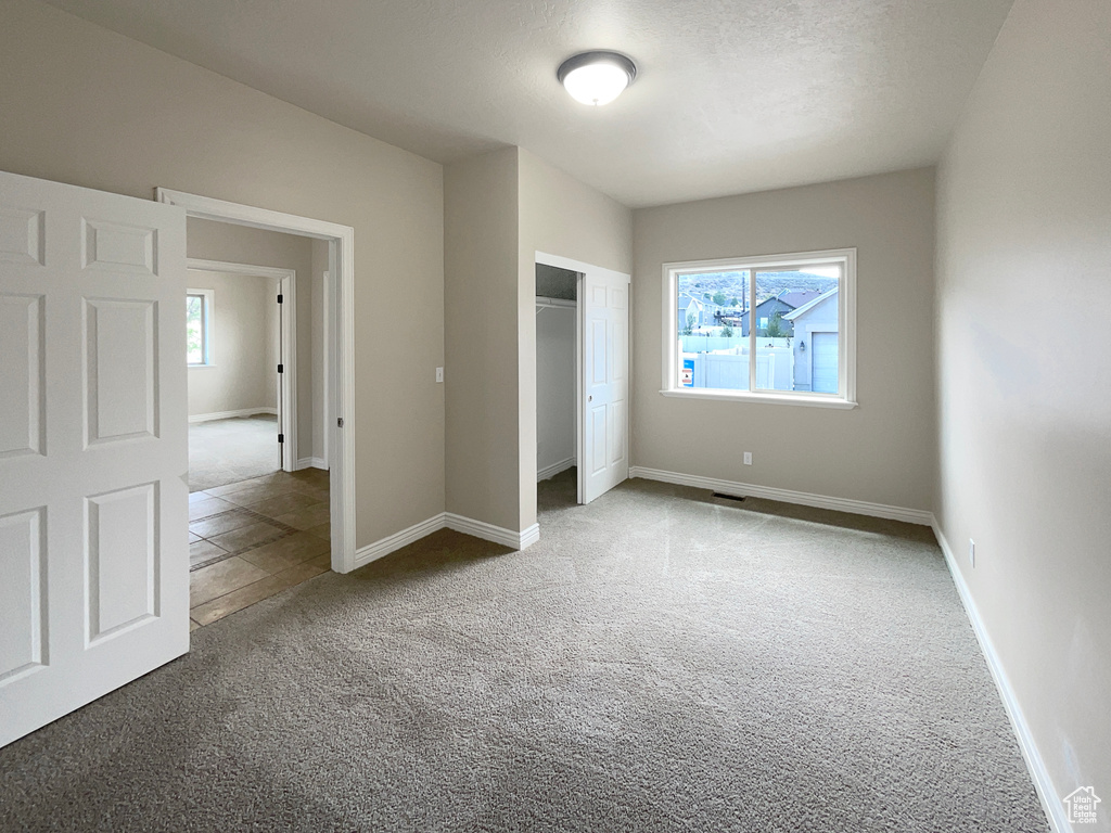 Unfurnished bedroom featuring carpet floors and a closet