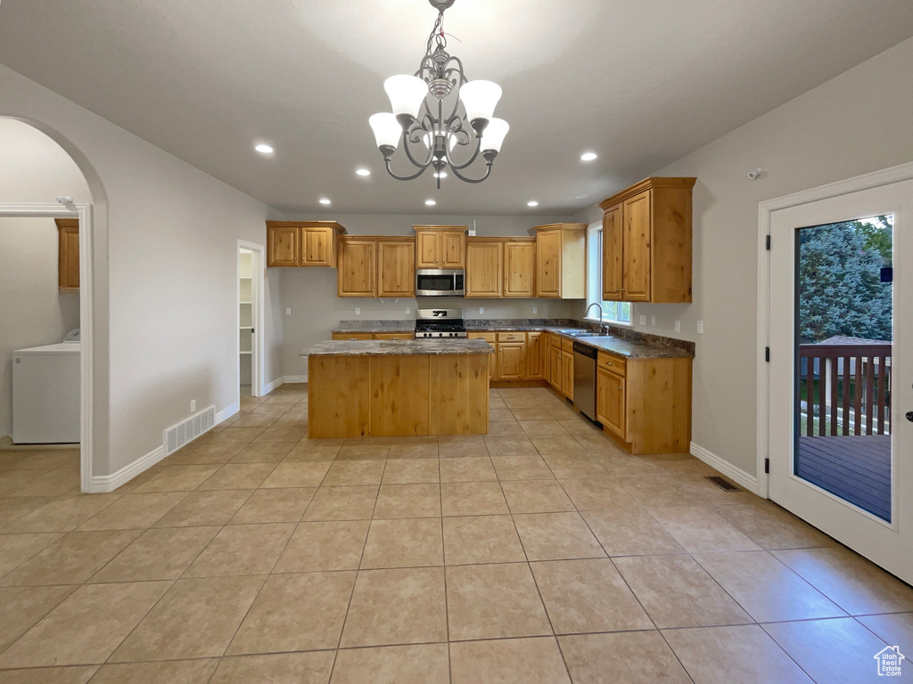 Kitchen with stainless steel appliances, washer / clothes dryer, arched walkways, recessed lighting, and a chandelier