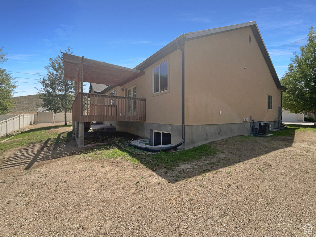 View of side of property featuring a deck and a cooling unit