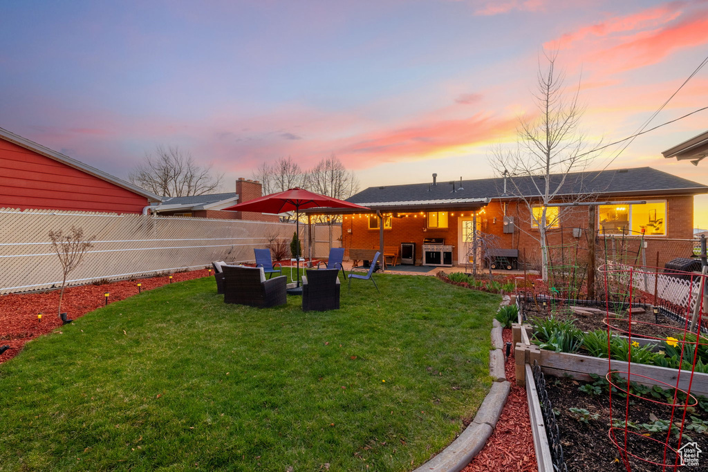 Yard at dusk with an outdoor hangout area and a patio