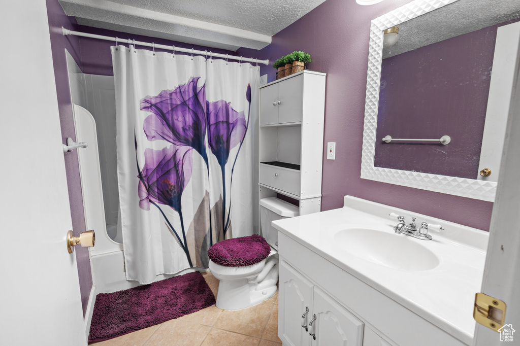 Full bathroom featuring toilet, shower / tub combo, tile flooring, a textured ceiling, and vanity