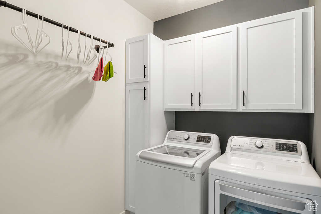 Laundry area with washing machine and clothes dryer and cabinets