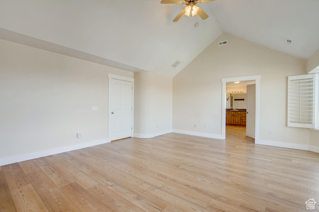 Unfurnished living room featuring ceiling fan, high vaulted ceiling, and light hardwood / wood-style floors