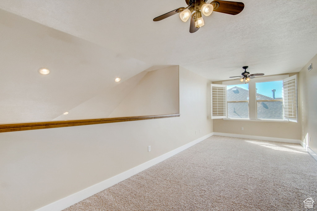 Spare room with light carpet, a textured ceiling, and ceiling fan