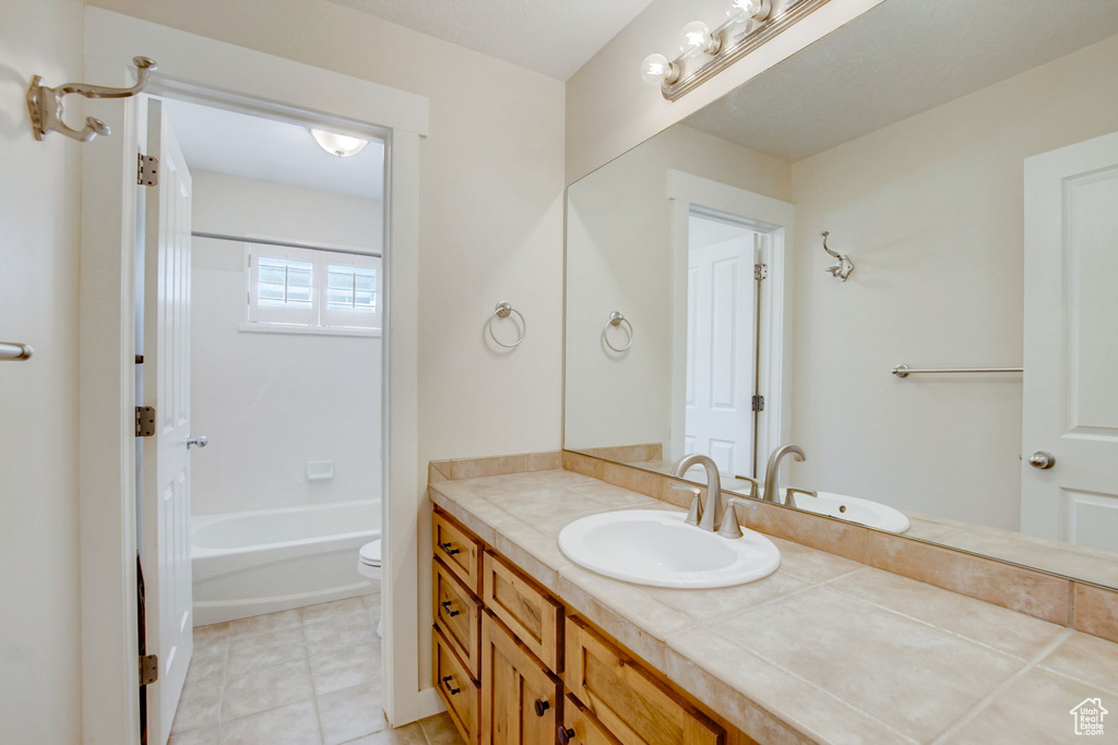 Full bathroom featuring tile flooring, shower / washtub combination, toilet, and vanity