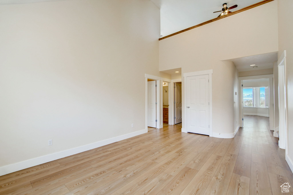 Unfurnished room featuring ceiling fan, a high ceiling, and light hardwood / wood-style floors