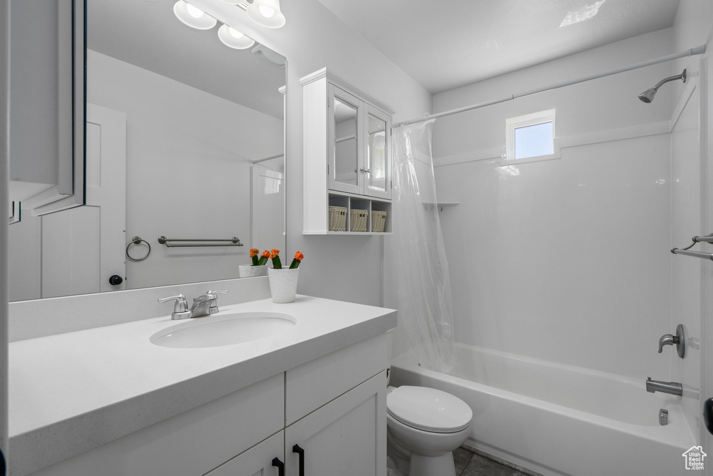 Full bathroom with oversized vanity, tile floors, shower / bath combo, and toilet