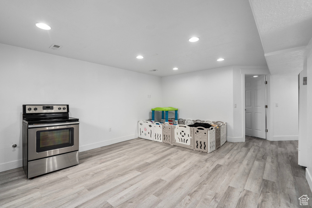 Kitchen featuring light wood-type flooring and stainless steel electric range oven