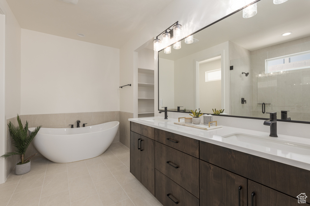 Bathroom featuring shower with separate bathtub, tile patterned floors, and dual bowl vanity