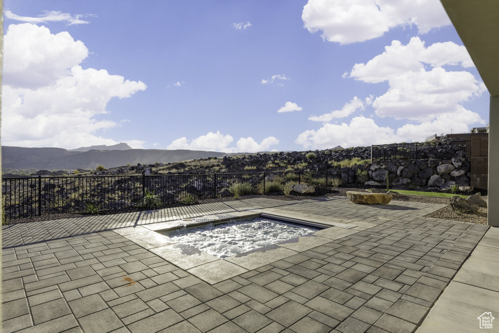 View of pool featuring a patio area, a mountain view, and an outdoor hot tub