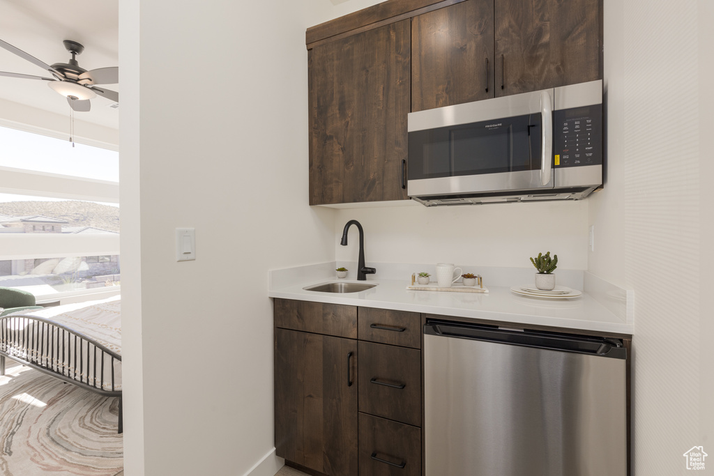 Kitchen featuring dark brown cabinets, appliances with stainless steel finishes, sink, and ceiling fan