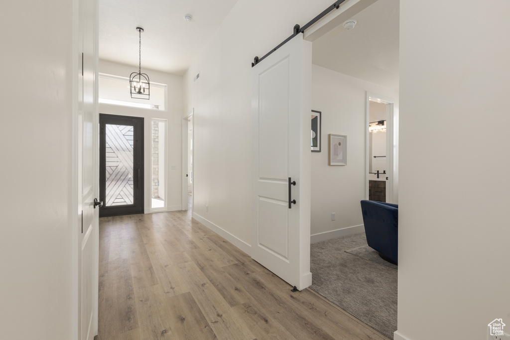 Foyer entrance with a barn door and wood-type flooring