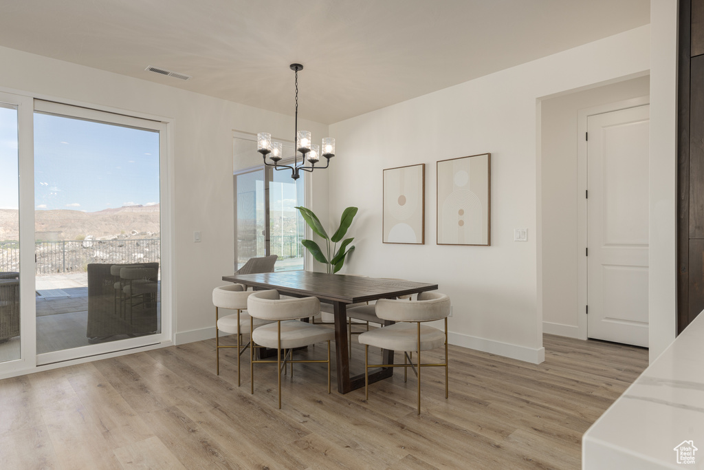 Dining area featuring light hardwood / wood-style flooring and an inviting chandelier