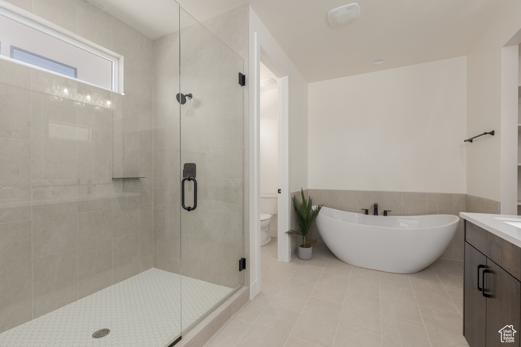 Full bathroom with vanity, plus walk in shower, toilet, and tile patterned floors