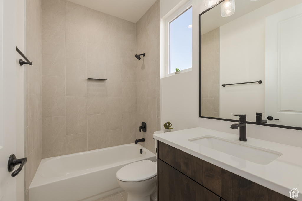 Full bathroom featuring toilet, vanity, and tiled shower / bath