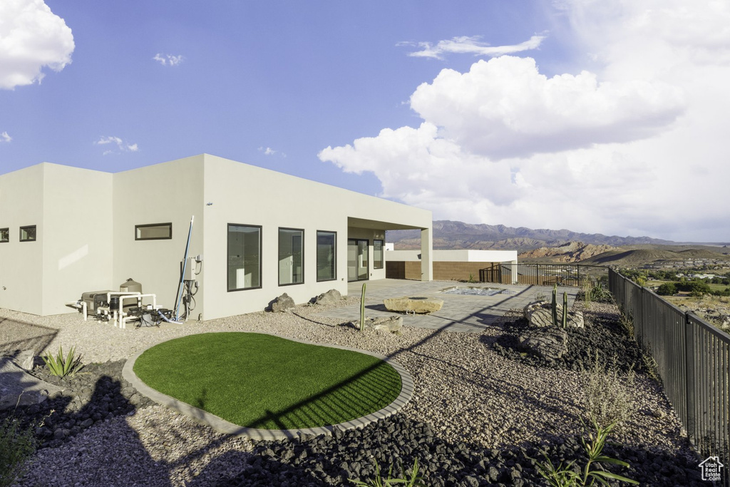 Back of house with a patio area and a mountain view