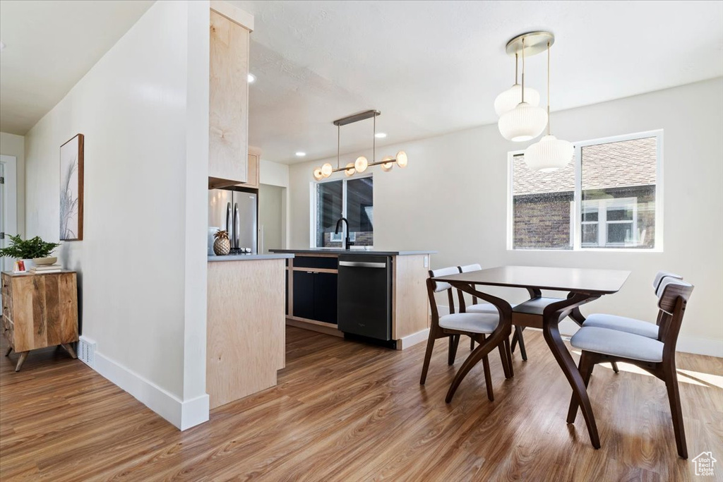 Interior space featuring hardwood / wood-style floors, decorative light fixtures, appliances with stainless steel finishes, and an inviting chandelier