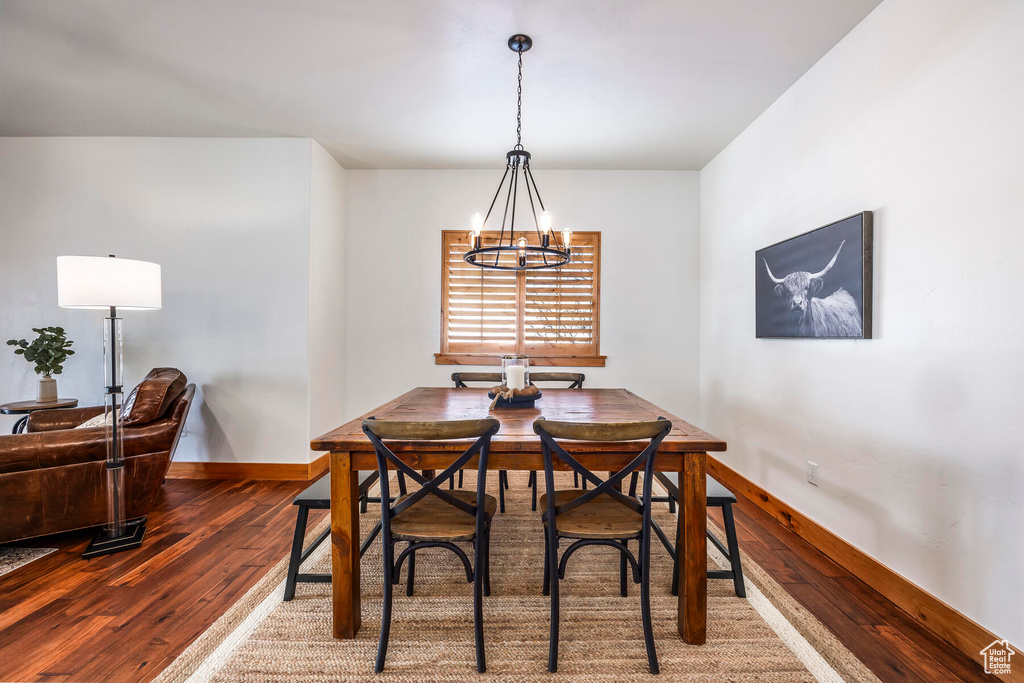 Dining space featuring dark hardwood / wood-style floors and a chandelier