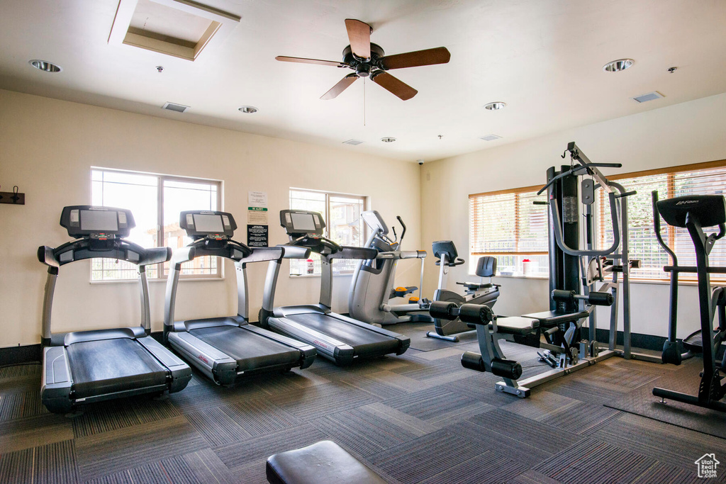 Workout area with dark colored carpet and ceiling fan