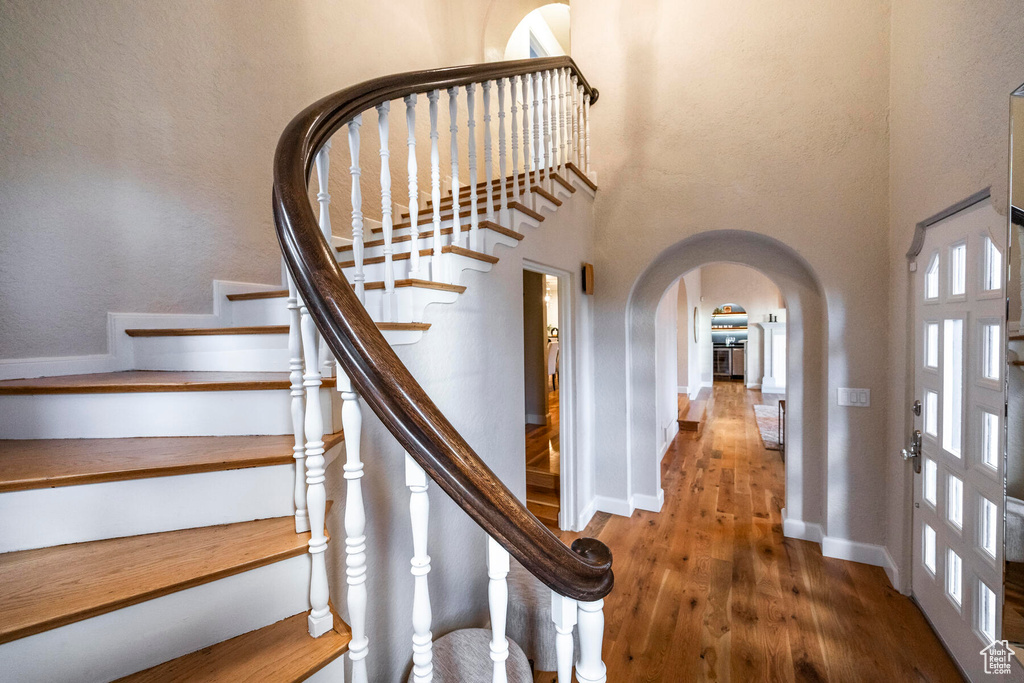 Stairway featuring a high ceiling and hardwood / wood-style flooring