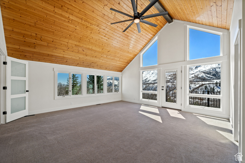 Interior space with high vaulted ceiling, ceiling fan, beamed ceiling, wood ceiling, and carpet