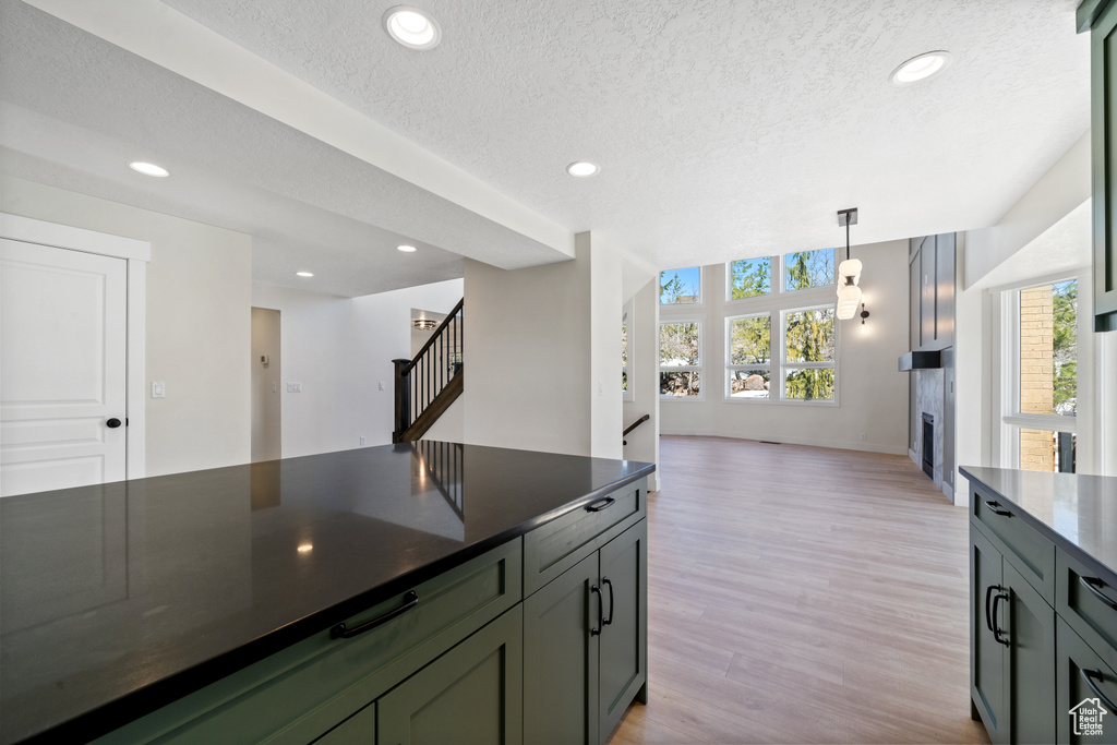 Kitchen featuring light hardwood / wood-style flooring, pendant lighting, and a textured ceiling