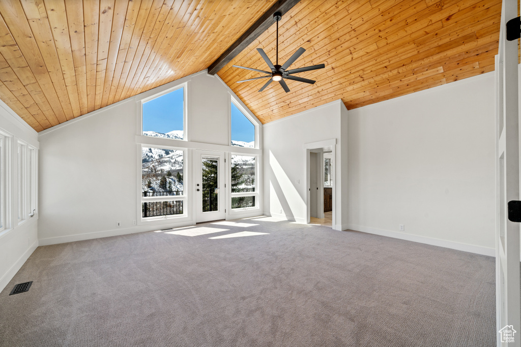 Unfurnished living room with high vaulted ceiling, ceiling fan, beam ceiling, light carpet, and wood ceiling