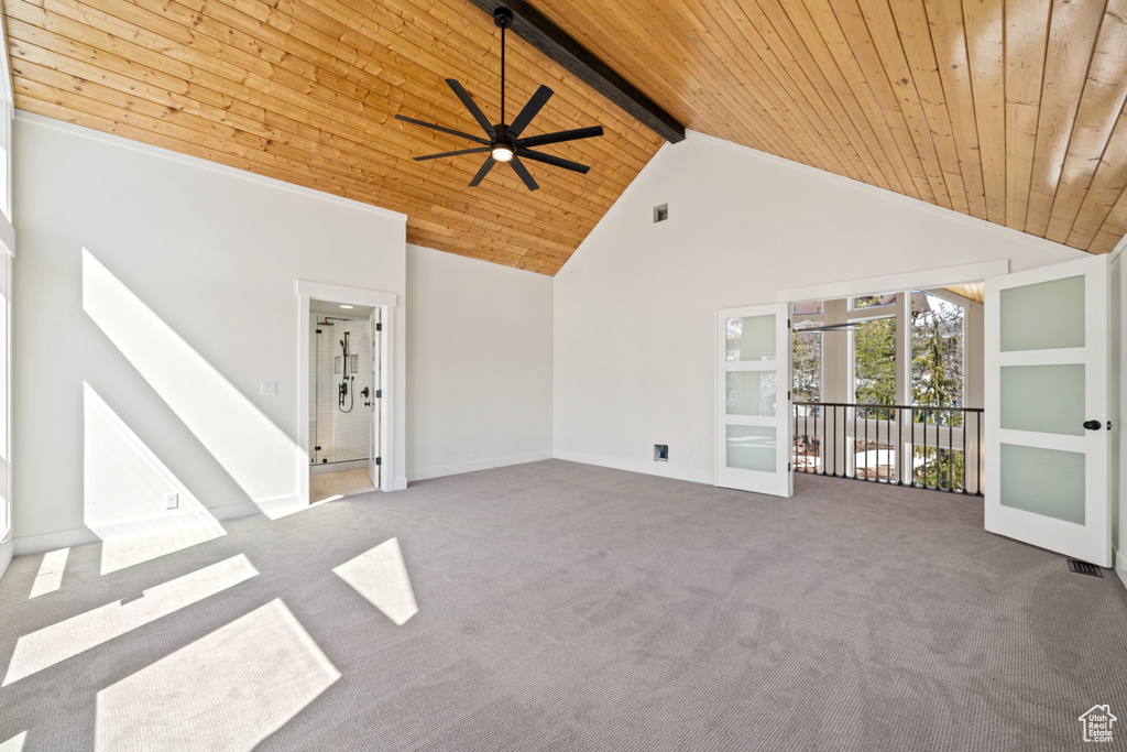 Carpeted empty room featuring high vaulted ceiling, ceiling fan, beamed ceiling, and wooden ceiling