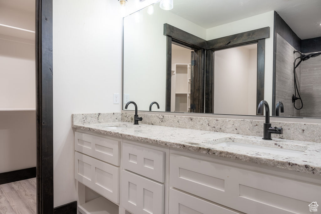 Bathroom featuring double sink, large vanity, and hardwood / wood-style floors