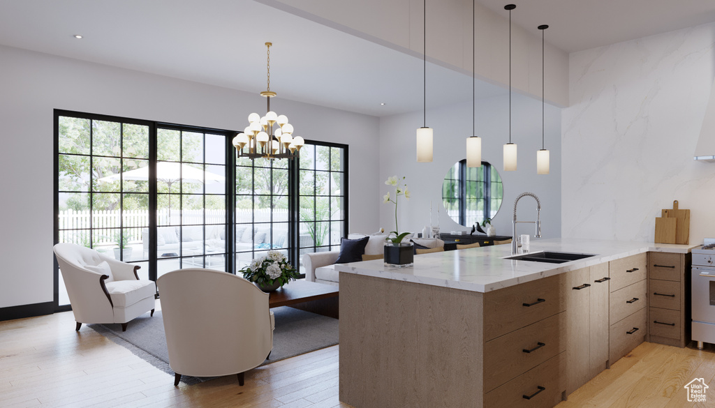 Kitchen featuring an inviting chandelier, light hardwood / wood-style floors, pendant lighting, light stone countertops, and sink