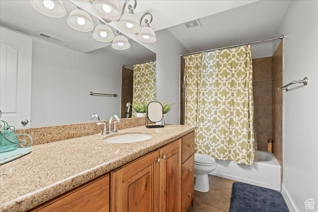 Full bathroom with vanity, toilet, shower / bath combo, and tile floors