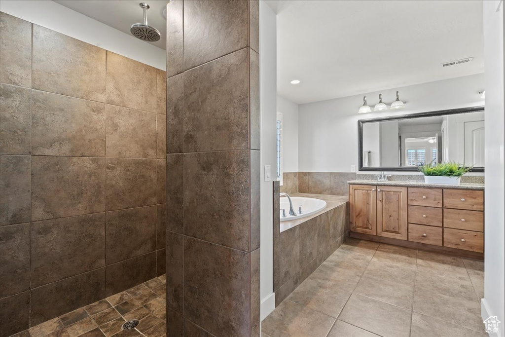 Bathroom featuring tile floors, plus walk in shower, and vanity with extensive cabinet space