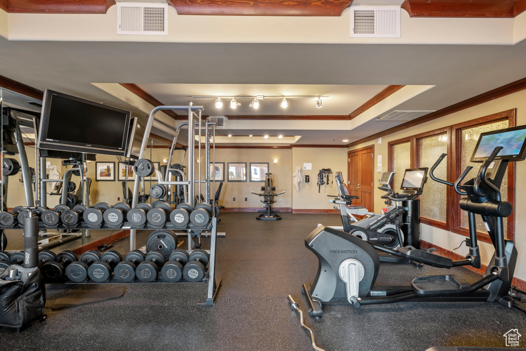 Exercise room with a raised ceiling and ornamental molding