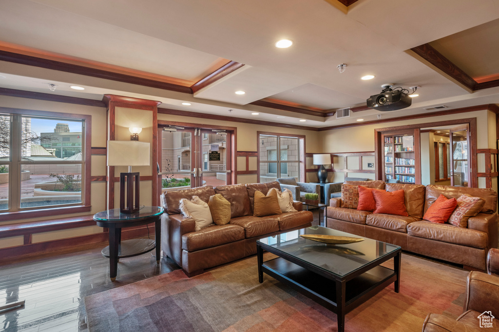 Living room with crown molding, a tray ceiling, french doors, and hardwood / wood-style flooring