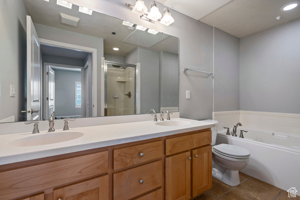 Full bathroom with toilet, vanity with extensive cabinet space, separate shower and tub, dual sinks, and tile flooring