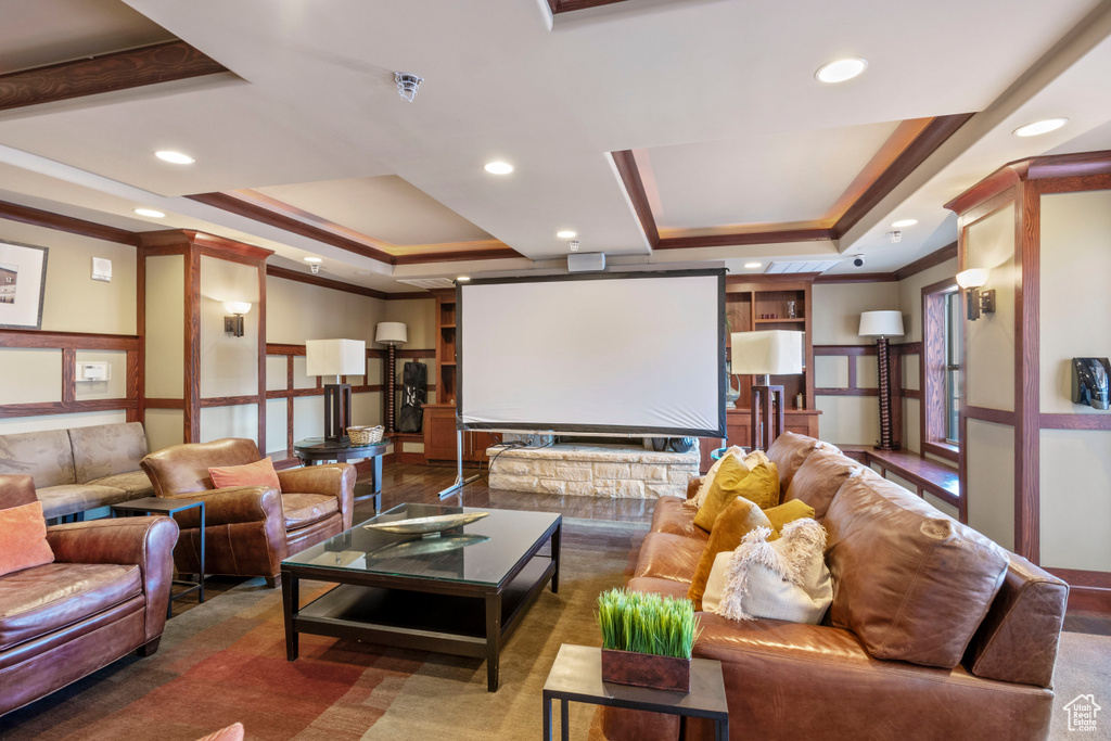 Home theater room with a raised ceiling and crown molding