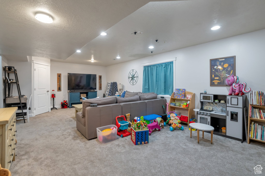 Game room featuring light carpet and a textured ceiling
