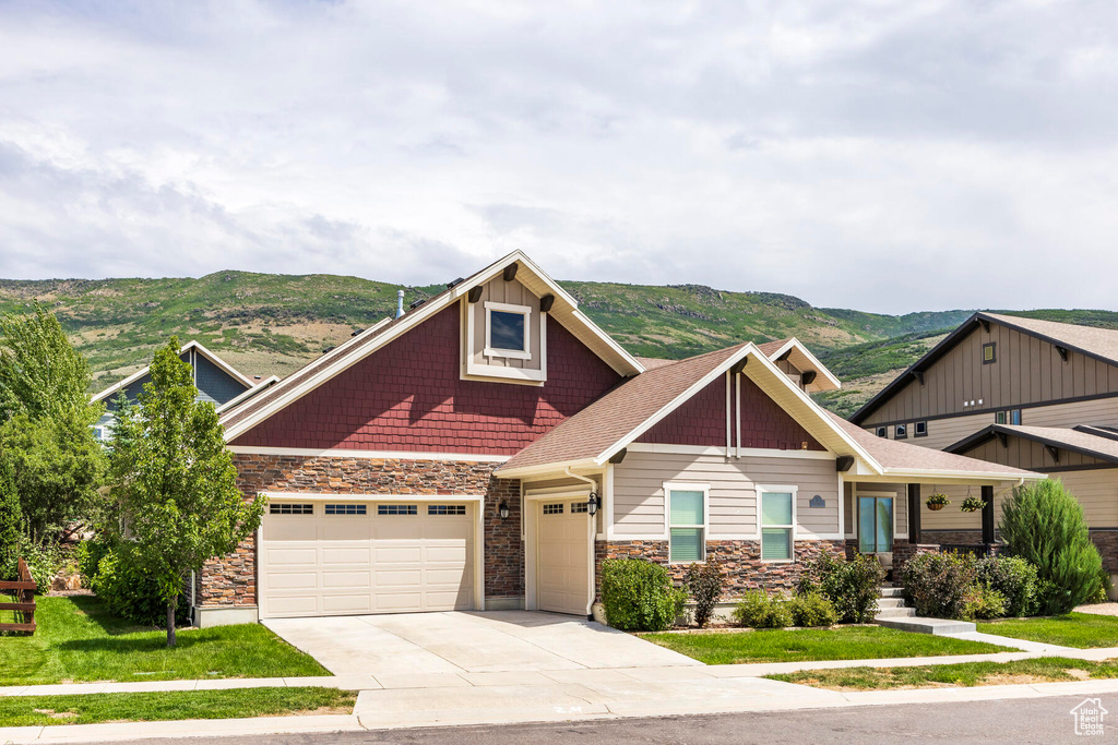 Craftsman-style home featuring a mountain view, a garage, and a front lawn