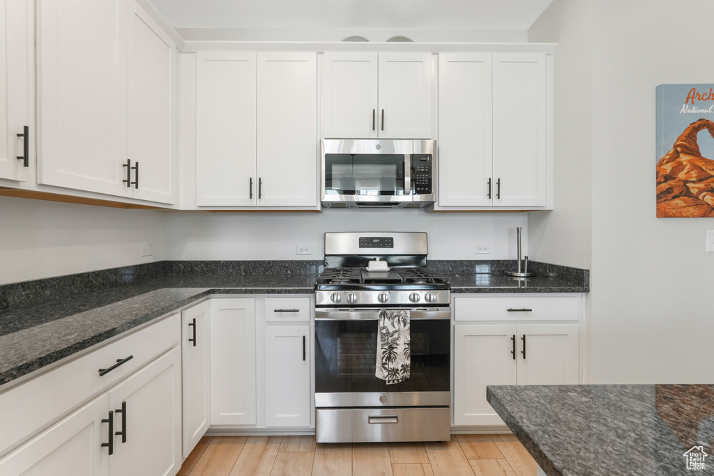 Kitchen featuring stainless steel appliances and white cabinets