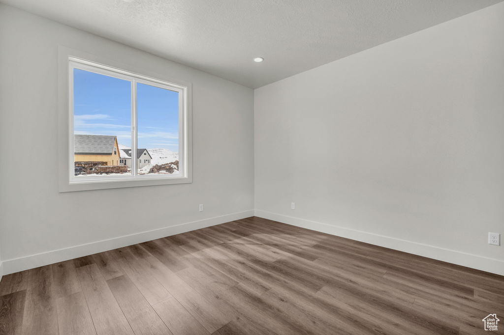 Spare room featuring plenty of natural light and dark hardwood / wood-style flooring