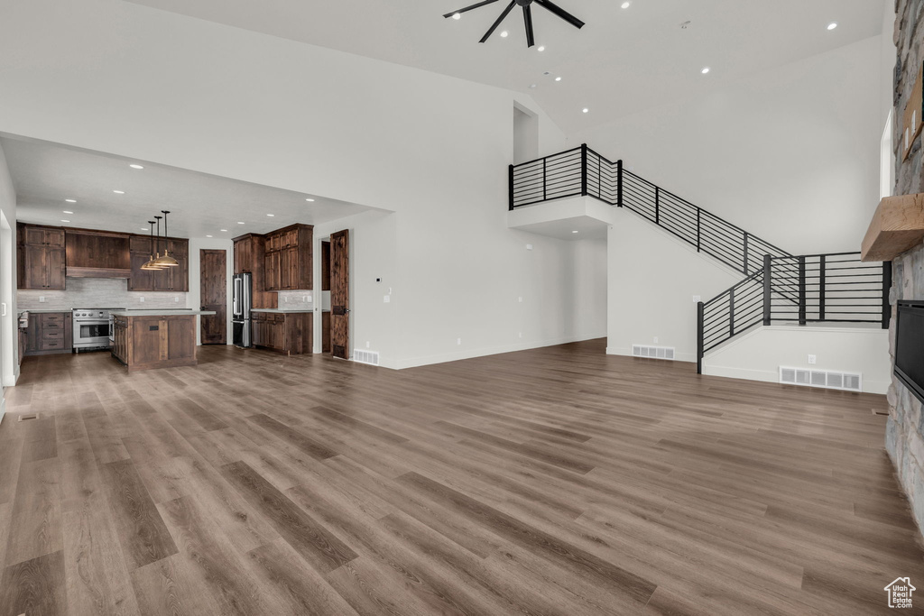 Unfurnished living room with a high ceiling and hardwood / wood-style flooring