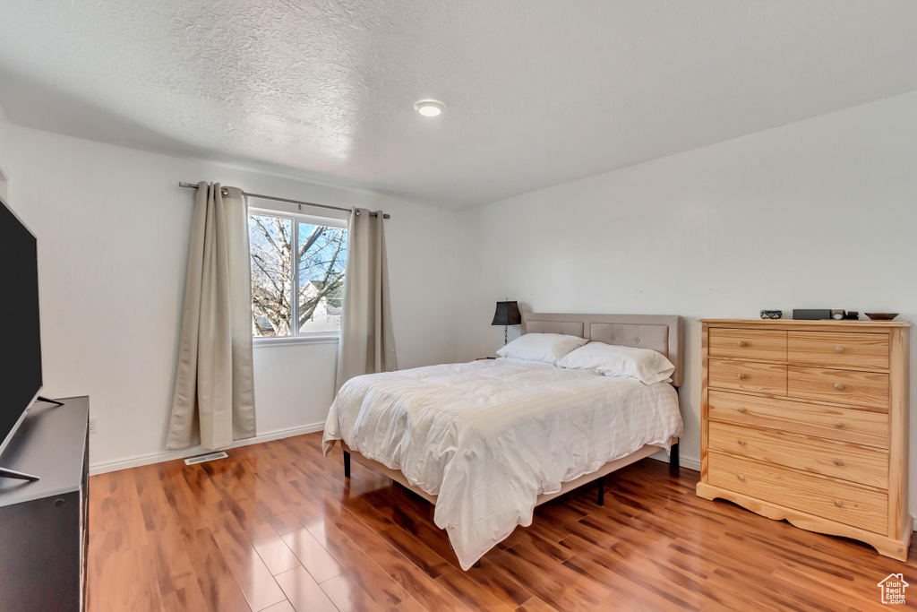 Bedroom featuring hardwood / wood-style floors and a textured ceiling
