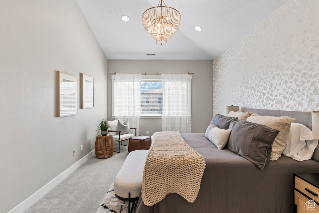 Bedroom featuring light carpet, a chandelier, and vaulted ceiling